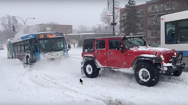 Видео: три внедорожника вытаскивают из снега автобус