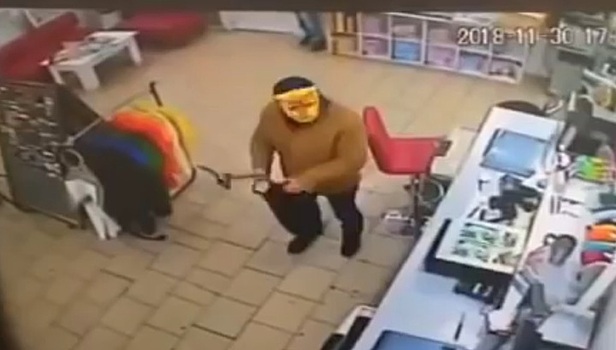 Сотрудники и посетители магазина скрутили грабителя с топором в маске кота. Видео
