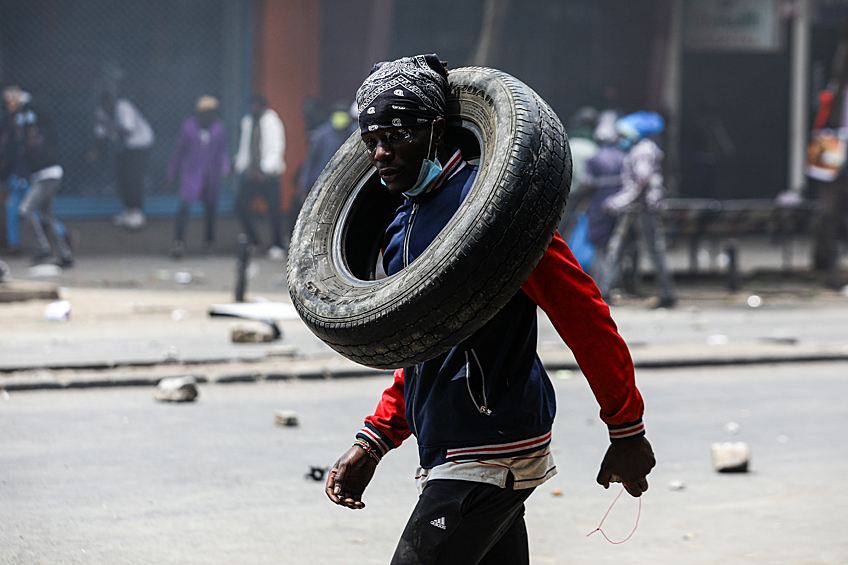 Мужчина несет покрышку во время антиправительственных протестов в Найроби, 2 июля 2024 года
