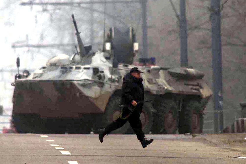 Сотрудник российских силовых структур бежит в укрытие возле Театрального центра на Дубровке, Москва, 25 октября 2002 года