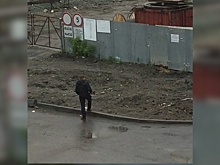 «Кого-то искал»: в Челябинске сняли на видео мужчину, разгуливавшего во дворе с ружьём