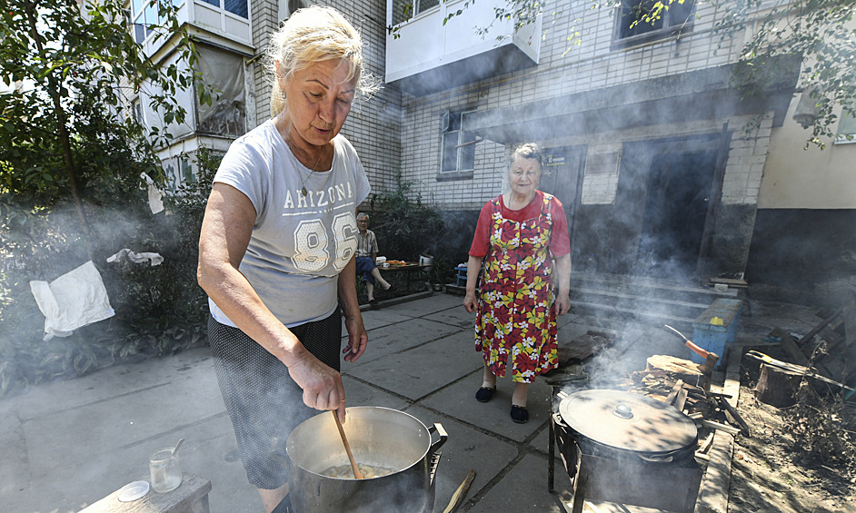 Местные жители готовят еду на улице