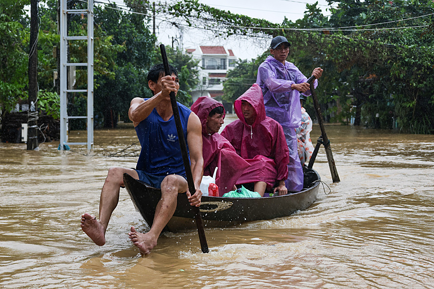 Местные жители передвигаются на лодке во время наводнения в Хойане