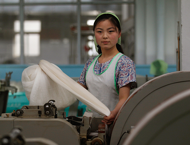 Женщина работает на Пхеньянской шелковой фабрике Ким Чен Сук в Пхеньяне