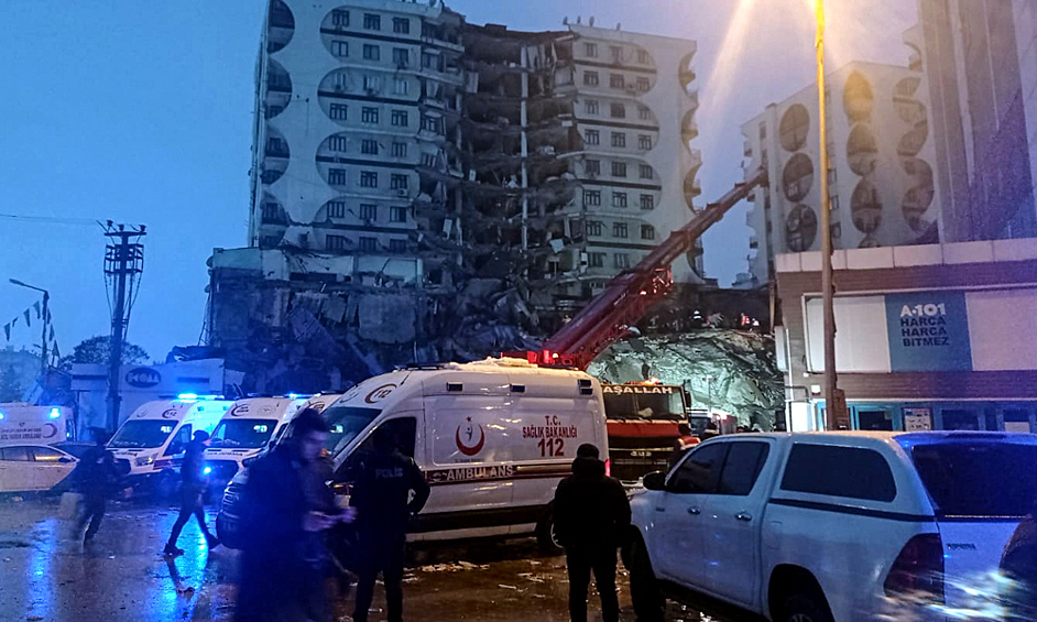 Люди у разрушенного здания пытаются помочь пострадавшим после сильного землетрясения.  Турция, город Диярбакыр