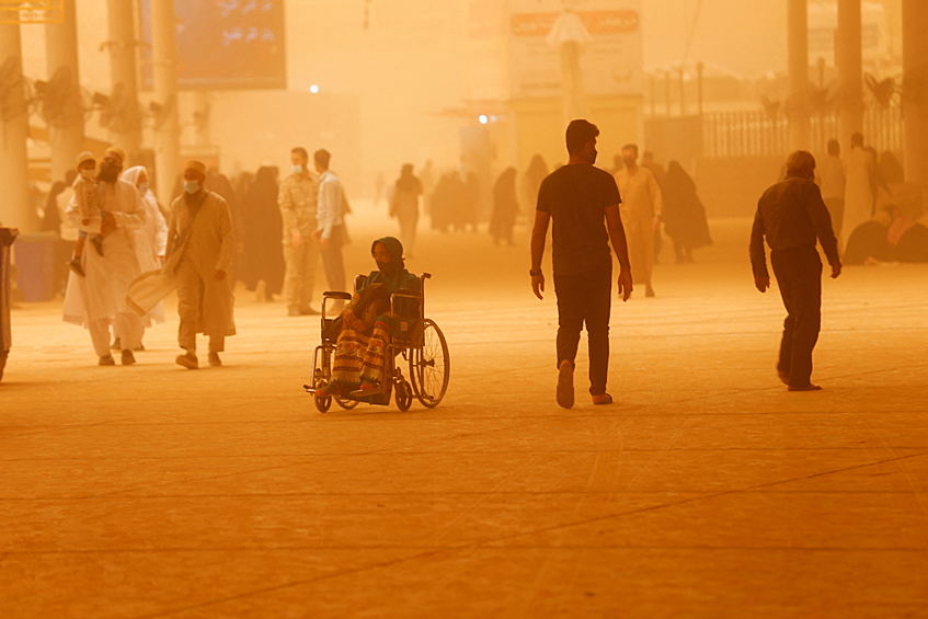 Люди на снимке во время песчаной бури в Наджафе