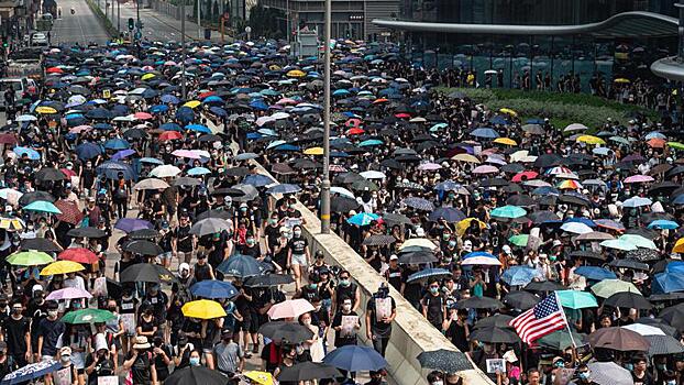 Гонконг негодует. Почему жители района выходят на митинги с зонтиками?