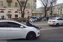 На видео попало, как в центре Воронежа парень катается на капоте машины