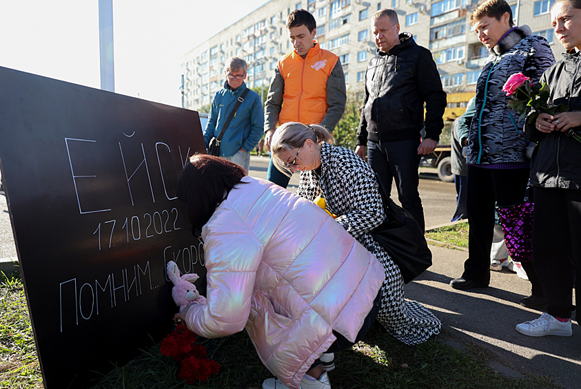 Люди у стихийного мемориала у многоэтажного дома, повреждённого в результате крушения сверхзвукового истребителя-бомбардировщика Су-34 в Ейске