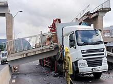 Водитель чудом уцелел, когда грузовик сбил пешеходный мост: видео