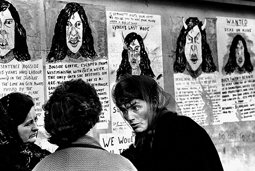 Три женщины на фоне серии постеров, критикующих республиканскую активистку Бернадетт Девлин Макалиски после ее избрания в Вестминстерский дворец. Северная Ирландия, 1969 год