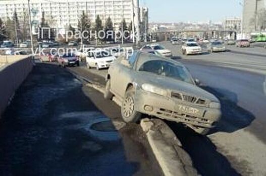 В Красноярске иномарка повисла на бордюре при въезде на Коммунальный мост