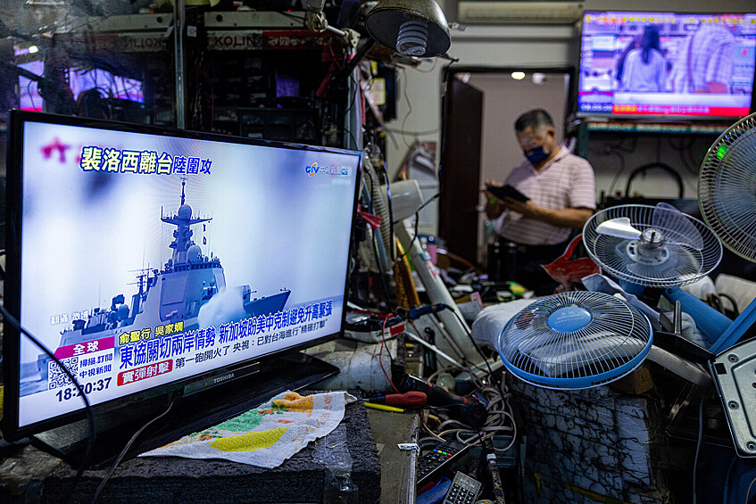 Новостной сюжет про учение вблизи Тайваньского пролива, который транслируется на экране телевизора в одном из магазинов по ремонту электрооборудования в городе Тайбэй, Тайвань, 4 августа 2022 года