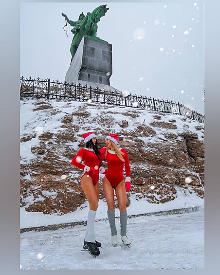 Девушки были одеты в обтягивающие красные боди, коньки, гольфы и в шапочки Санта-Клауса.