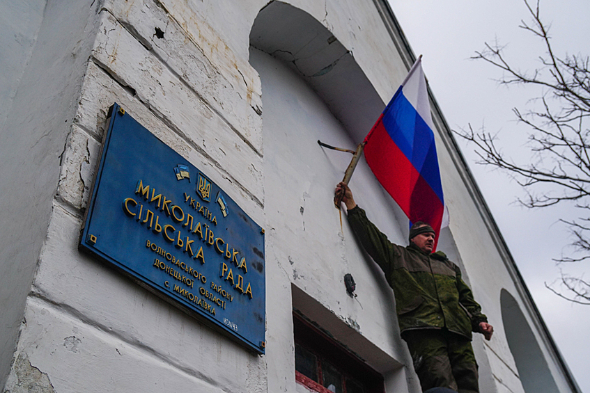 Военнослужащие народной милиции ДНР и ВС РФ водружают флаги России и Донецкой народной республики на здании администрации села Николаевка