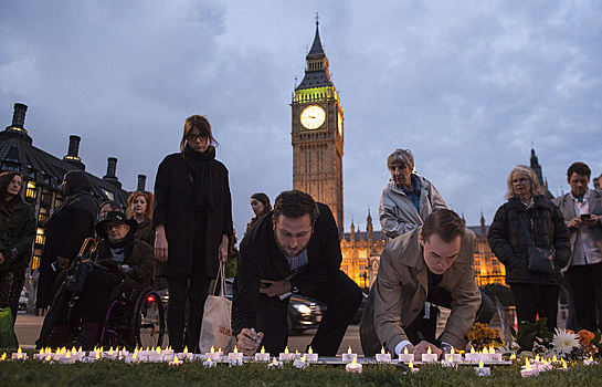 Жители Лондона несут цветы к парламенту Великобритании
