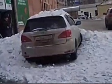 Упавший с крыши снег завалил припаркованный автомобиль в Прокопьевске
