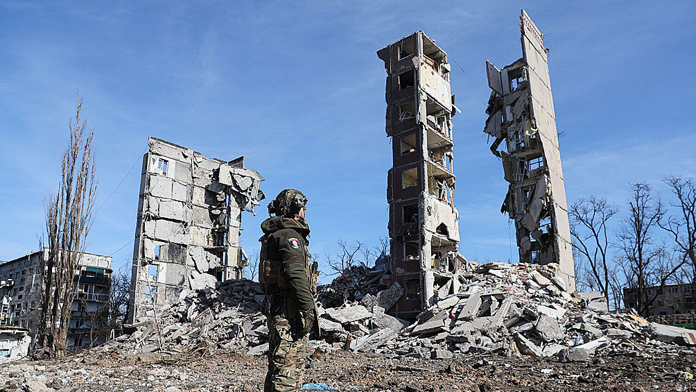 Военнослужащий у разрушенного многоэтажного дома в Авдеевке, февраль 2024 года