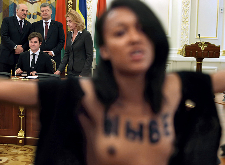 Участница группы Femen пытается помешать визиту президента Белоруссии Александра Лукашенко на Украину. Киев, 2017 год