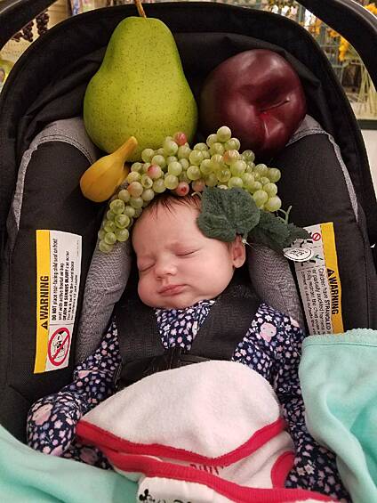 Просто папа решил украсить ребенка пластиковыми фруктами.