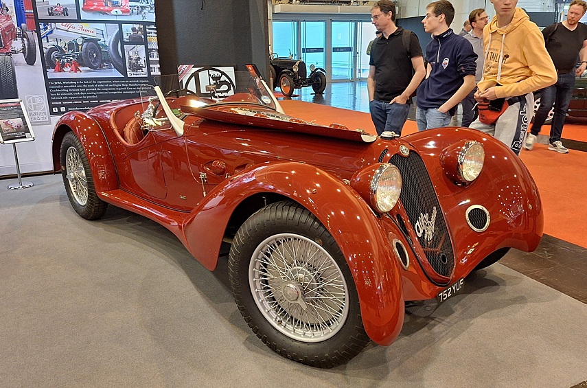 Родстер Alfa Romeo 8C 2900 1937 года выпуска — дорожно-гоночная машина, созданная специально для изнурительных соревнований вроде «24 часов Ле-Мана» или Mille Miglia. Это настоящая вершина довоенной гоночной инженерии: у неё независимая подвеска всех колёс, вынесенная назад для лучшей развесовки коробка передач и мощный 2,9 литровый двигатель конструкции Витторио Яно — рядная «восьмёрка» с двумя компрессорами Roots, выдававшая 225 л.с. Этот экземпляр снабжён открытым кузовом от ателье Zagato — или, по крайней мере, изготовленным по его проекту.