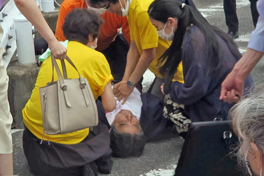 Бывший премьер-министр Японии Синдзо Абэ лежит на земле после стрельбы, 8 июля 2022 года