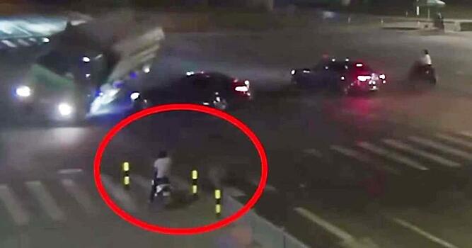 Скутерист спасся бегством от опрокинувшегося грузовика с навозом в Китае