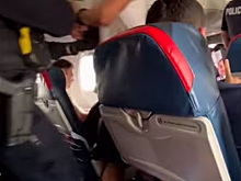 Американца высадили с самолета за попытку открыть дверь во время полета