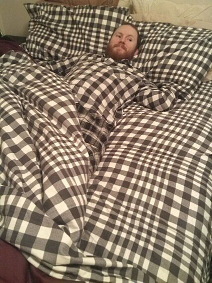 Пижама этого мужчины так удачно вписывается в принт постельного белья, что кажется, будто одна голова лежит на кровати!