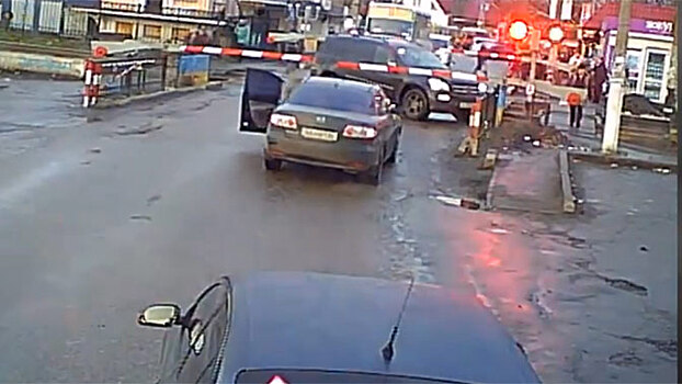 Между двух шлагбаумов: водитель Mercedes в Киеве спасся от поезда в последнюю секунду
