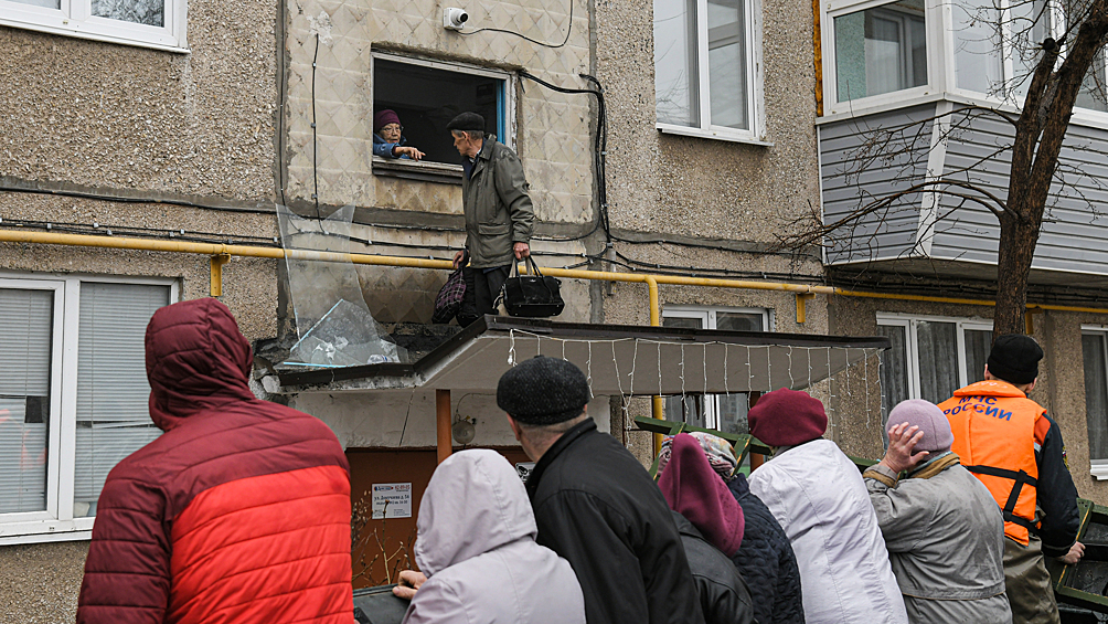 Эвакуация жителей затопленного из-за прорыва дамбы района Орска. Жители выбираются через окно на козырек подъезда, оттуда сотрудники МЧС помогают им спуститься в лодку