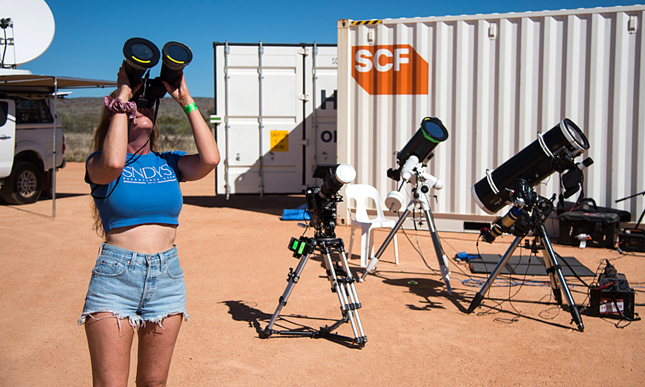 Девушка наблюдает гибридное солнечное затмение в Австралии