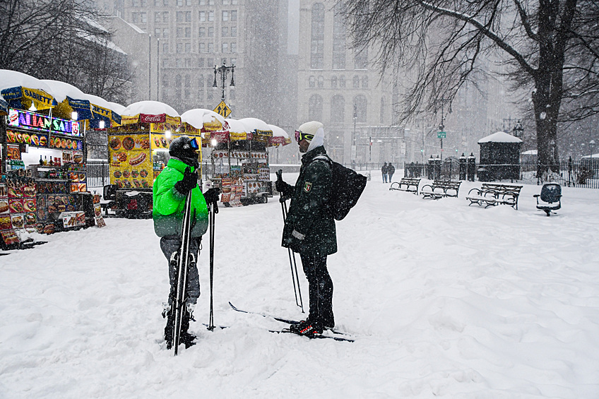 Прохожие во время снегопада в Нью-Йорке