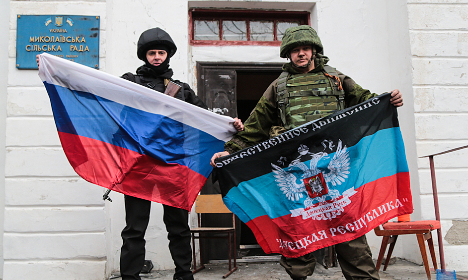 Бойцы Народной милиции Донецкой народной республики держат флаги РФ и ДНР у дверей сельсовета Николаевки