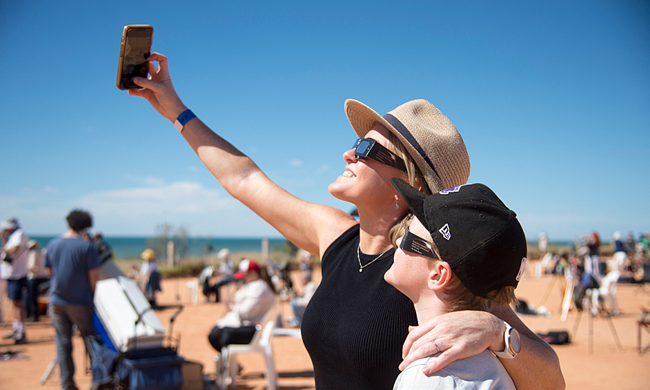 Люди наблюдают гибридное солнечное затмение в Австралии