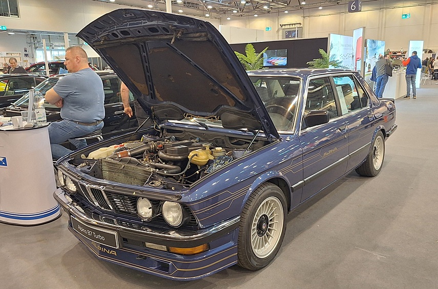 Раз уж мы начали с BMW, не можем не поделиться снимком Альпины B7 Turbo — на момент выхода в 1984 году это был быстрейший седан, который вообще можно было купить за деньги! Большую рядную «шестёрку» M30B34 объёмом 3430 куб.см снабдили турбиной KKK K27, специально изготовленными поршнями Mahle, головкой от мотора M102 от BMW 745i, оригинальным распредвалом и коллекторами. Это позволило довести отдачу до 300-320 л.с., в зависимости от модификации. Таким образом, Alpina оказывалась заметно мощнее и быстрее 286-сильной BMW M5: по данным измерений журнала Auto, Motor und Sport наиболее мощная версия разгонялась до 100 км/ч за 6,1 секунды и достигала 265 км/ч. В общей сложности с 1984 по 1987 год фирма из города Бухлоэ изготовила 280 автомобилей.