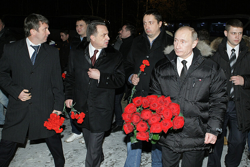 Председатель правительства РФ Владимир Путин на Люблинском кладбище перед возложением цветов к могиле болельщика «Спартака» Егора Свиридова, убитого в Москве в начале декабря. На первом плане второй слева - министр спорта, туризма и молодежной политики РФ Виталий Мутко. На втором плане второй справа - президент «Всероссийского объединения болельщиков» Александр Шпрыгин, 21 декабря 2010 года