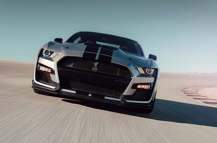 Mustang Shelby GT500. Это не просто очень крутой «Мустанг». На момент появления он был мощнейшим дорожным автомобилем Ford в истории и настоящей отдушиной для тех, кто считал Dodge Challenger SRT Hellcat слишком неотесанным и невоспитанным. К слову, компрессорный Hemi V8 у «Хеллкэта» нижневальный с двумя клапанами на цилиндр. В то время как мустанговский Predator («Хищник») объемом 5,2 литра — с четырьмя распредвалами и огромным механическим нагнетателем. Отдача — 771 л.с. Согласно замерам журнала Car and Driver, до 97 км/ч (60 миль/ч) Shelby ускоряется за 3,6 секунды. И заслуга в этом отнюдь не одного двигателя.