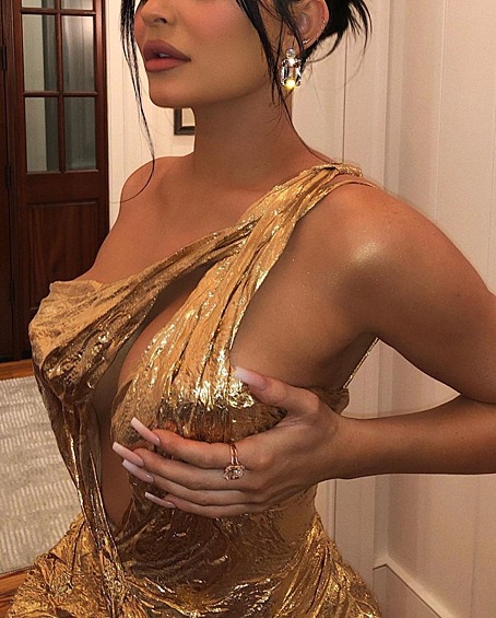 Кайли Дженнер поддерживает роскошную грудь, демонстрируя новое золотистое платье.