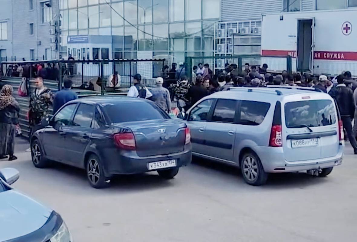 Сотни мигрантов окружили здание в российском городе и попали на видео