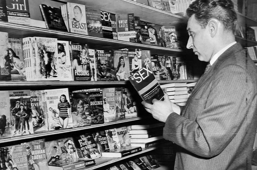 Детектив нью-йоркской полиции изучает эротические книги во время рейда против нелегальных порноматериалов, 1960 год. 
