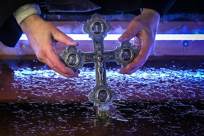 Священнослужитель совершает чин освящения воды во время Крещенских купаний на Дворцовом пруду у Храма Живоначальной Троицы в Останкине, 18 января 2026 года