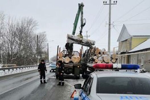 В Воронежской области груженный бревнами КамАЗ съехал в водосток