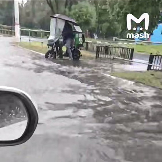 Курьер на электровелосипеде во время дождя