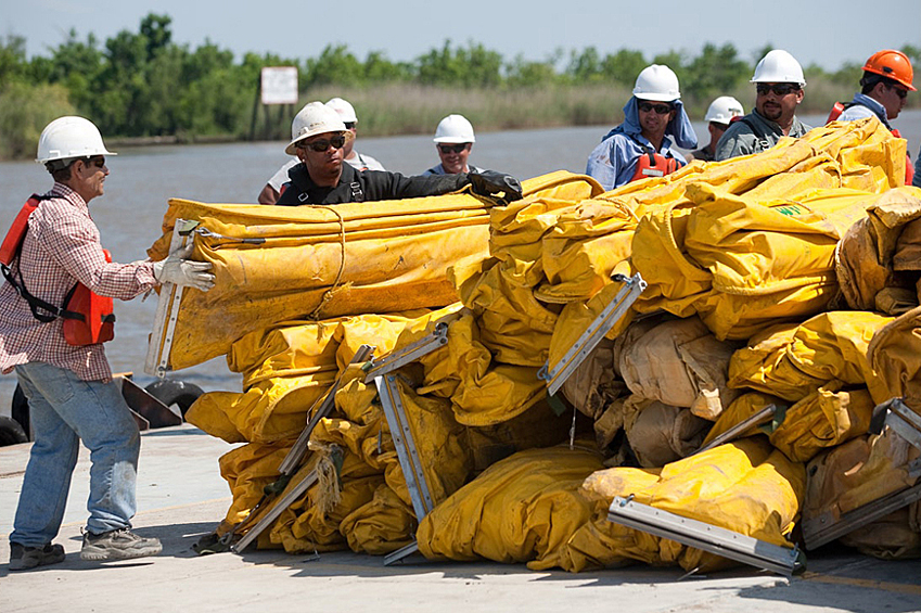 На фото: рабочие экологических служб США готовят боновые заграждения.