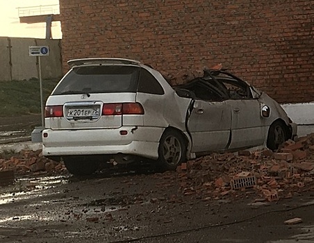 Машину сплющило рухнувшими с крыши здания кирпичами