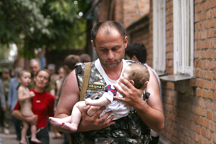 Спецназовец несет на руках спасенную девочку во время захвата террористами школы № 1 города Беслана в 2004 году. В течение двух с половиной дней террористы удерживали в заминированном здании более 1100 заложников. 