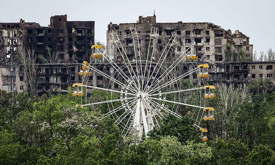 Вид на жилые дома и колесо обозрения, поврежденные в результате боевых действий