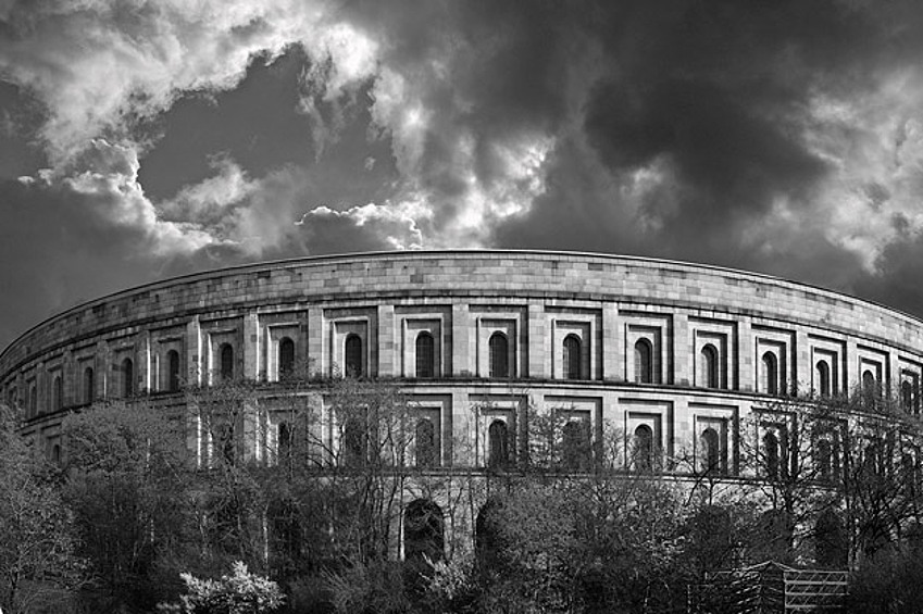Территория съездов НСДАП в Нюрнберге, Зал собраний. По проекту, здание должно было быть накрыто стеклянной крышей без промежуточных опор. Архитектура здания, а особенно его внешний фасад напоминают Колизей в Риме. Строительство началось в 1935 году, но так и не было закончено. Сейчас здание находится под охраной государства.