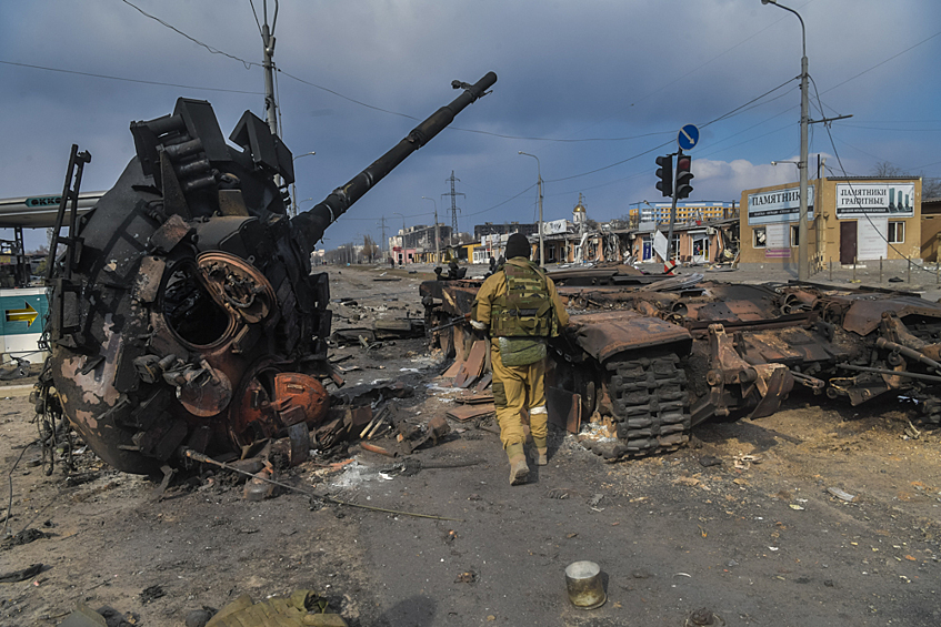 Боец Народной милиции ДНР у подбитого танка армии ДНР на улице Куприна в Мариуполе
